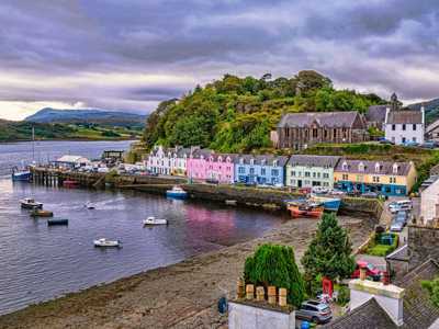 Moody skies above colourful harbour front of Portree on the Isle of Skye